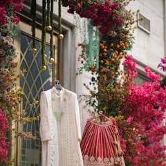 Traditional indian wedding outfits displayed amidst colorful floral decorations