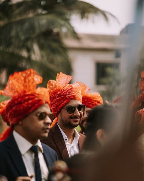 A group of men wearing orange turbans and ties