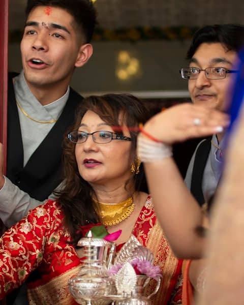 Woman in red and white floral dress sitting beside man in black suit
